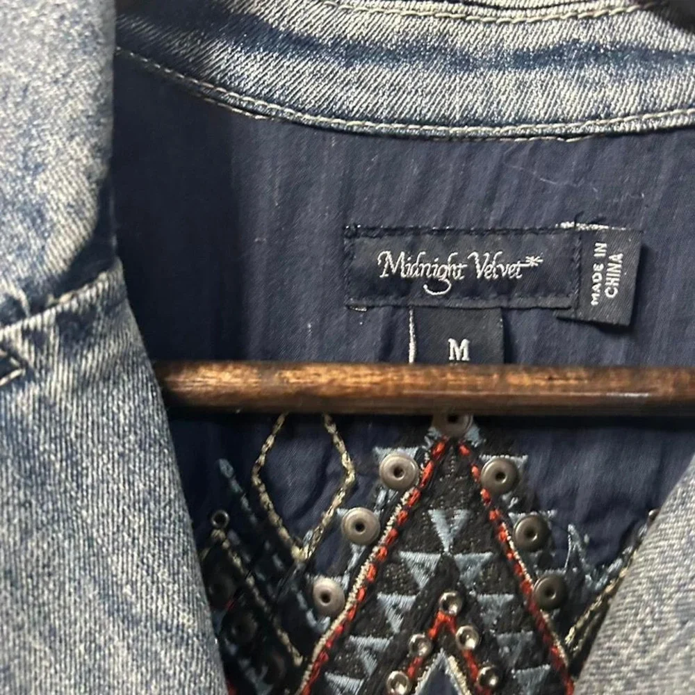 Blue denim jacket with embroidered sleeves,‎ featuring a boho western vibe